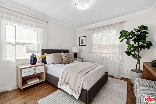 bedroom with crown molding and hardwood / wood-style floors