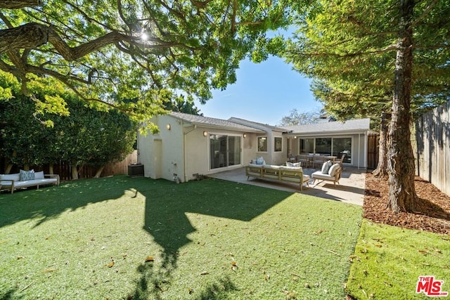 rear view of property with an outdoor hangout area, cooling unit, a patio, and a yard