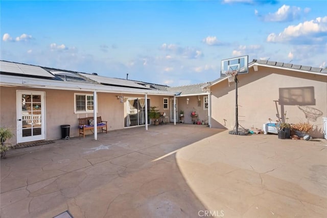 back of house with a patio area and solar panels