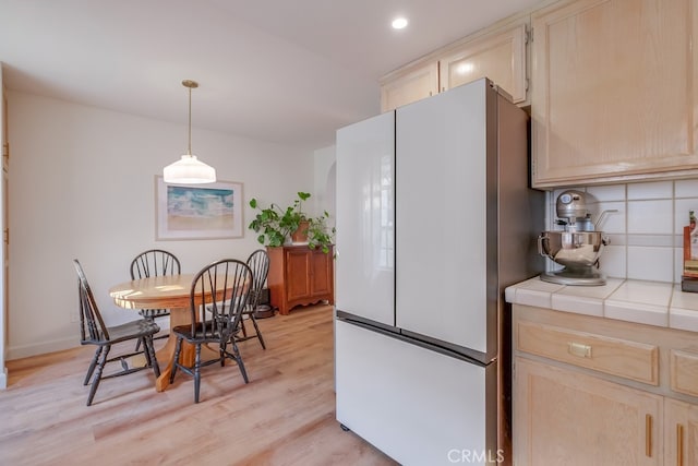 kitchen featuring tile countertops, light brown cabinets, and white refrigerator