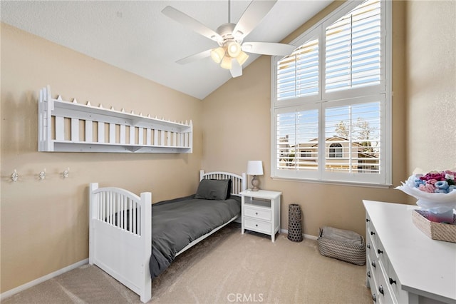 bedroom with a ceiling fan, light carpet, vaulted ceiling, and baseboards