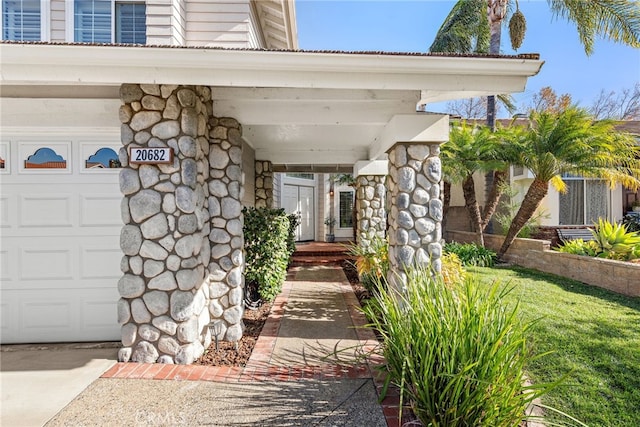 entrance to property with stone siding and an attached garage