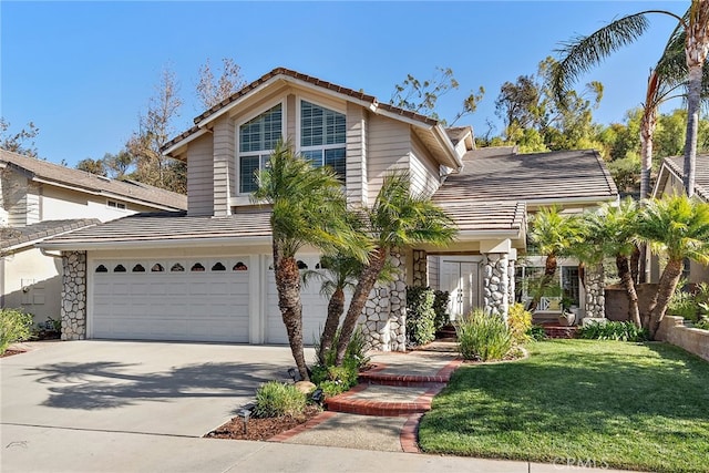 view of property with a garage and a front lawn