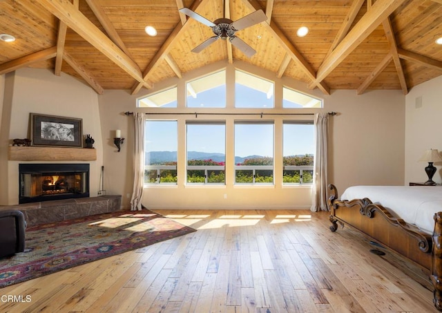 bedroom with a mountain view, light hardwood / wood-style floors, multiple windows, and ceiling fan