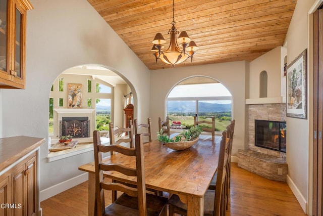 dining space featuring light wood-type flooring, vaulted ceiling, wood ceiling, and an inviting chandelier