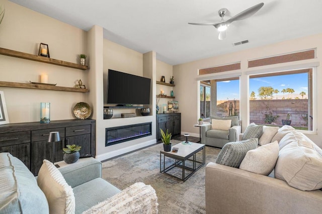 living room with ceiling fan and built in shelves