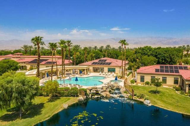 view of swimming pool with a water view, a patio area, and a yard