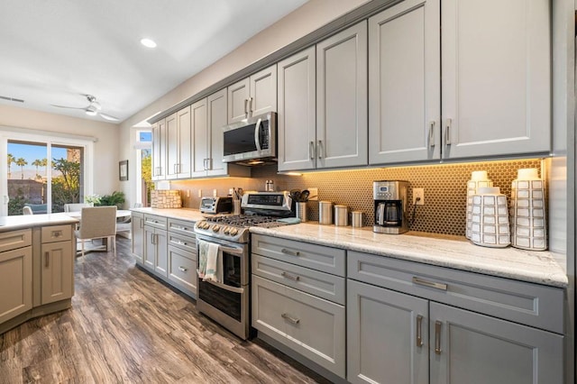 kitchen featuring ceiling fan, backsplash, appliances with stainless steel finishes, and gray cabinetry