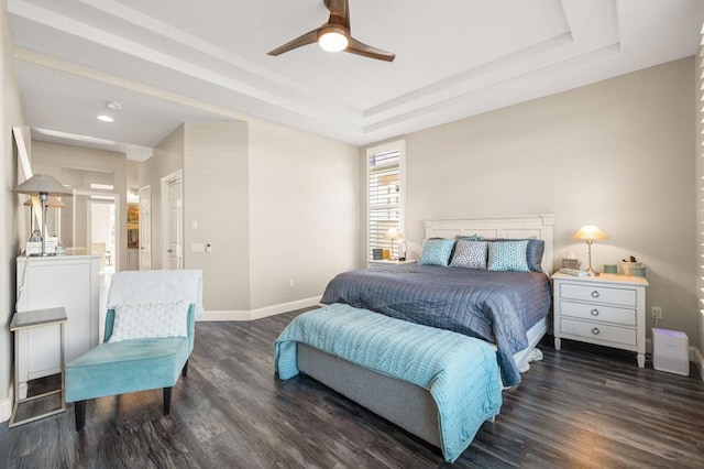 bedroom featuring ensuite bathroom, ceiling fan, dark hardwood / wood-style flooring, and a raised ceiling