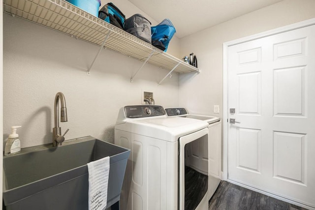 washroom featuring dark wood-type flooring, sink, and washing machine and clothes dryer