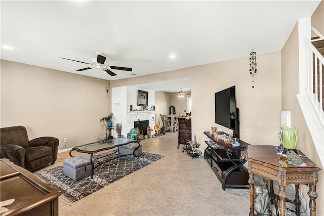 living room featuring ceiling fan, light tile patterned floors, and a fireplace