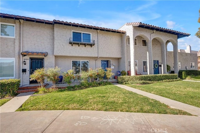 mediterranean / spanish home featuring a front yard