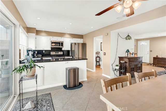 kitchen with ceiling fan, sink, white cabinetry, stainless steel appliances, and light tile patterned floors