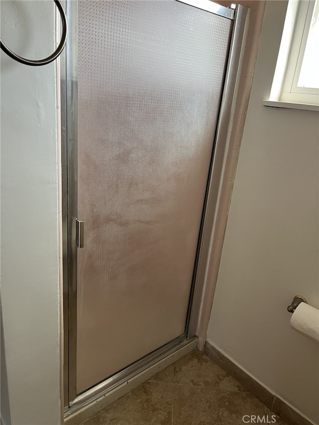 bathroom with a shower with door