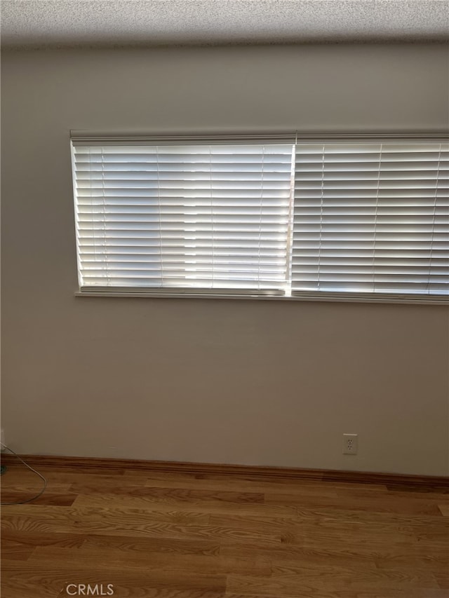 unfurnished room featuring hardwood / wood-style floors and a textured ceiling