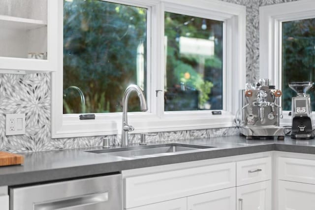 bar with stainless steel dishwasher, sink, and white cabinets