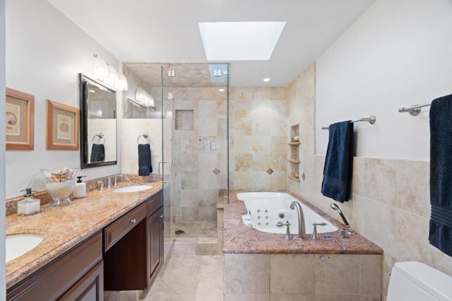 full bathroom with a skylight, independent shower and bath, tile walls, vanity, and toilet