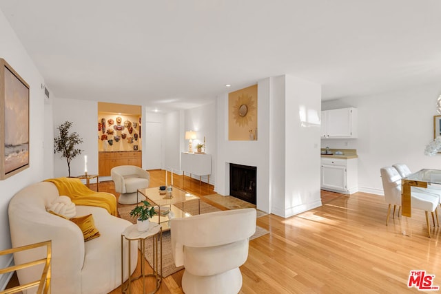 living room featuring light wood-type flooring and sink