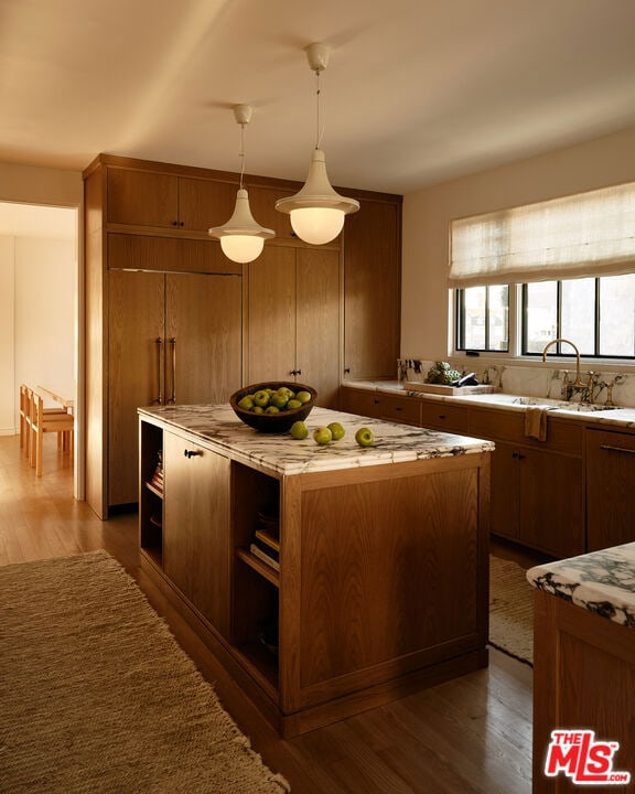 kitchen featuring decorative light fixtures, dark hardwood / wood-style floors, sink, and a center island