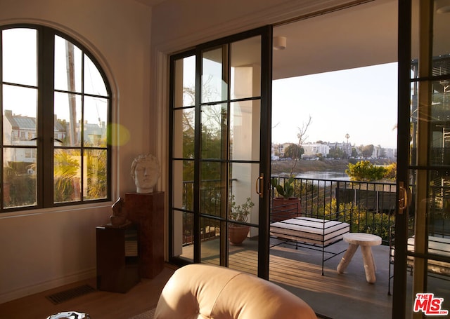 entryway with hardwood / wood-style floors and a water view