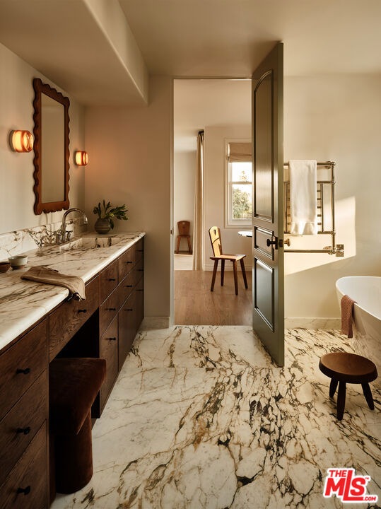 bathroom featuring vanity and a bath