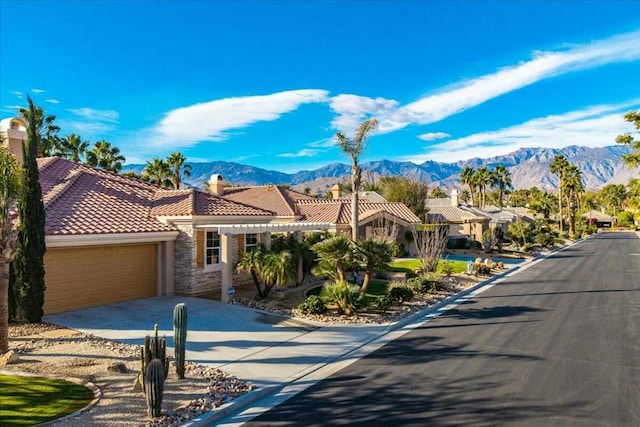 mediterranean / spanish-style home with a garage and a mountain view