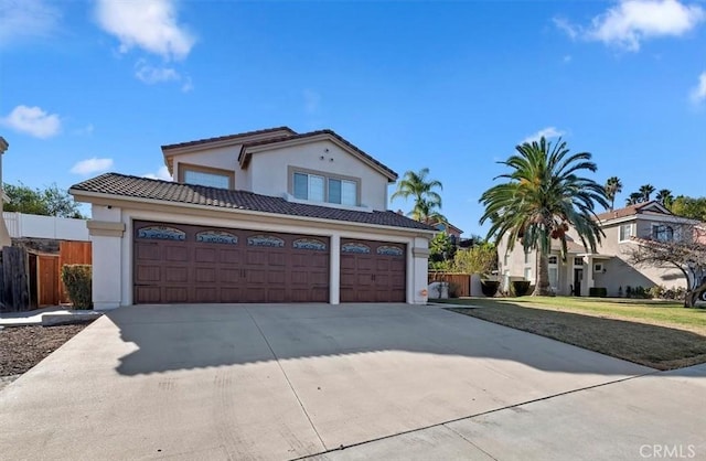 mediterranean / spanish house featuring a front yard and a garage