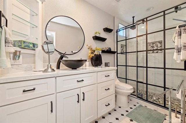 bathroom featuring toilet, vanity, and tiled shower