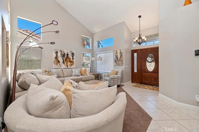 tiled living room featuring high vaulted ceiling and a notable chandelier