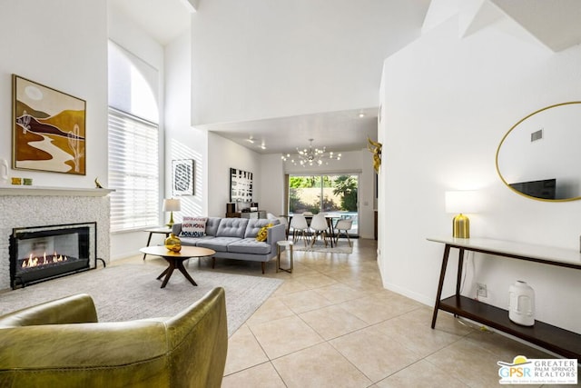 tiled living room with a healthy amount of sunlight, a high ceiling, and a chandelier