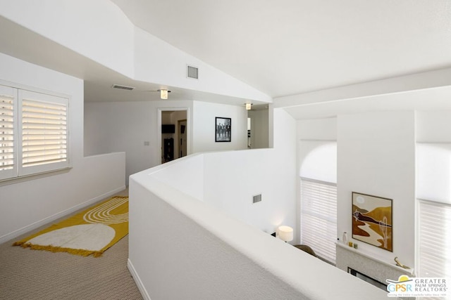 hall featuring carpet and lofted ceiling