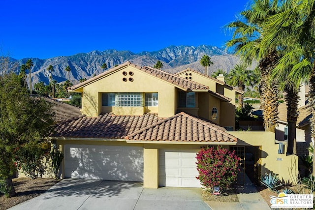 mediterranean / spanish-style house with a garage and a mountain view