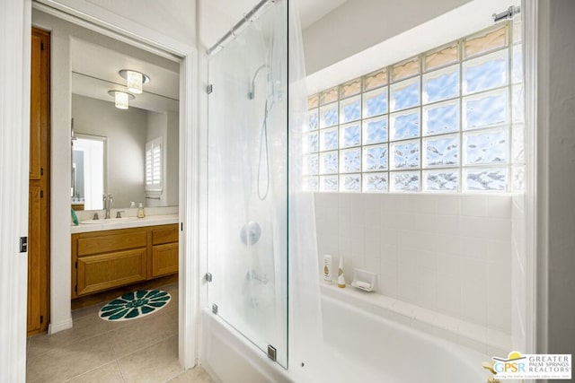 bathroom with bathing tub / shower combination, vanity, a healthy amount of sunlight, and tile patterned flooring