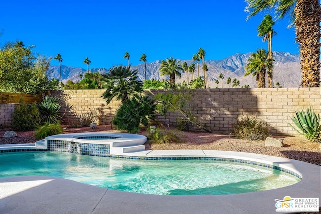 view of pool featuring cooling unit, pool water feature, a mountain view, and an in ground hot tub