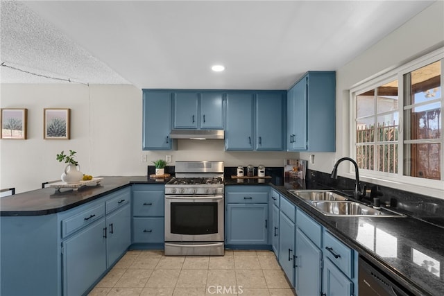 kitchen featuring light tile patterned floors, kitchen peninsula, stainless steel appliances, blue cabinetry, and sink