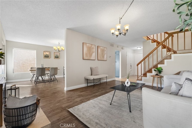 living room featuring a textured ceiling, an inviting chandelier, and dark hardwood / wood-style floors