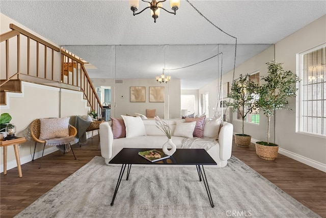 living room featuring a notable chandelier, a textured ceiling, and hardwood / wood-style floors