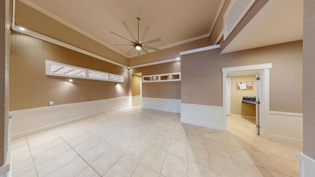 tiled empty room featuring ceiling fan and ornamental molding