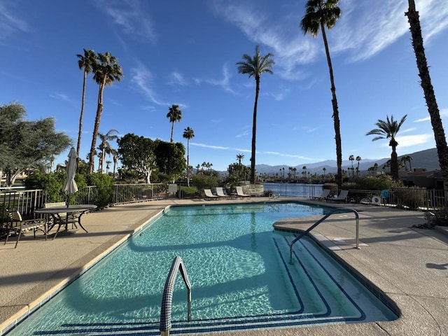 view of swimming pool featuring a patio area and a mountain view