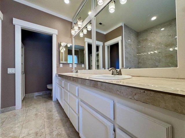 bathroom with toilet, vanity, and crown molding