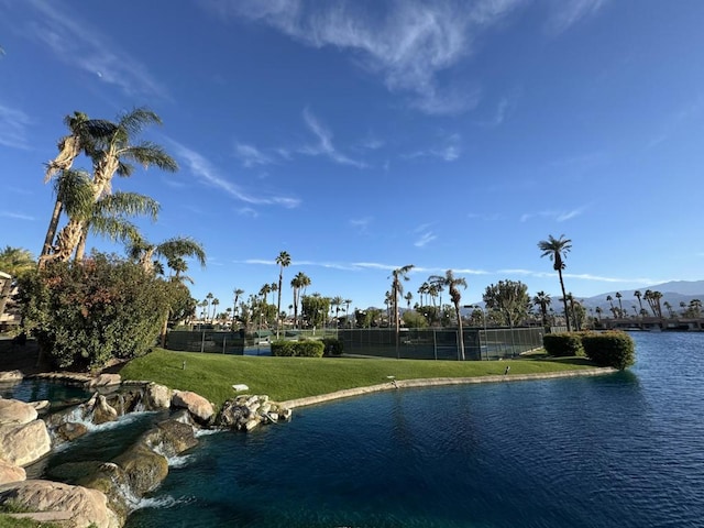 view of swimming pool with a water and mountain view and a lawn