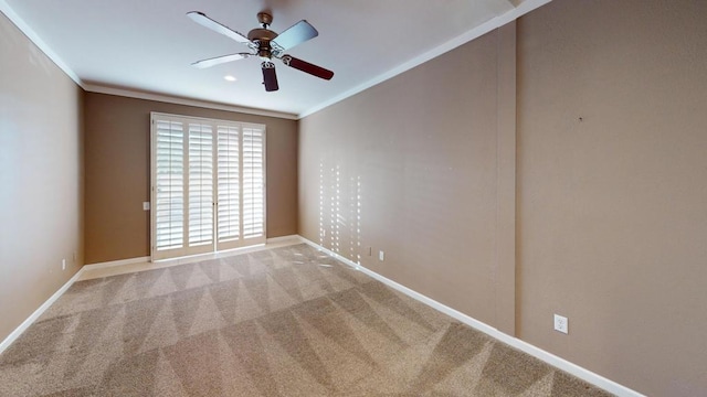 carpeted spare room featuring ceiling fan and crown molding