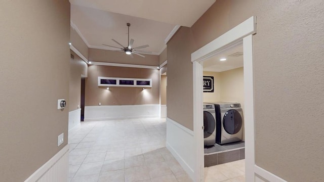 corridor with light tile patterned floors, crown molding, and washing machine and clothes dryer