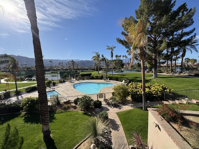 view of pool with a water and mountain view, a yard, and a patio