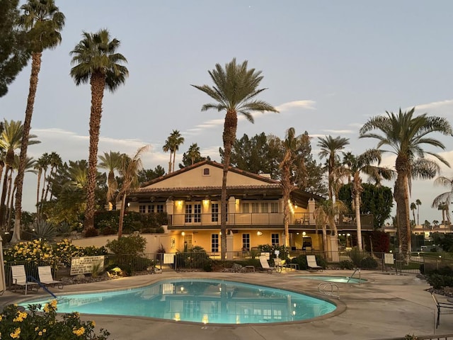 pool at dusk with a patio