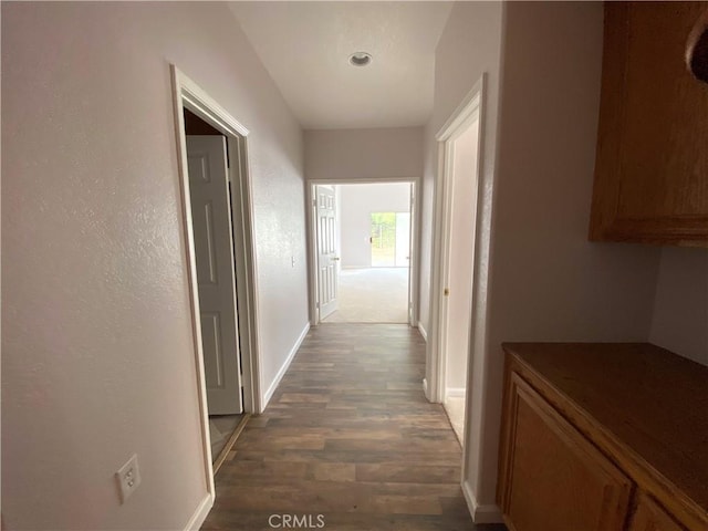 corridor with dark hardwood / wood-style flooring