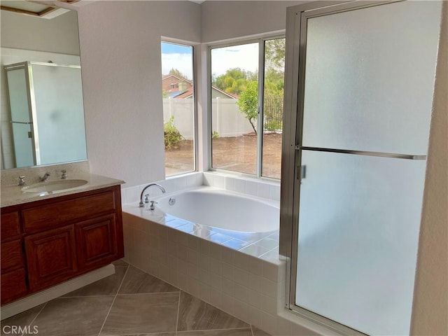 bathroom with shower with separate bathtub, vanity, and tile patterned flooring