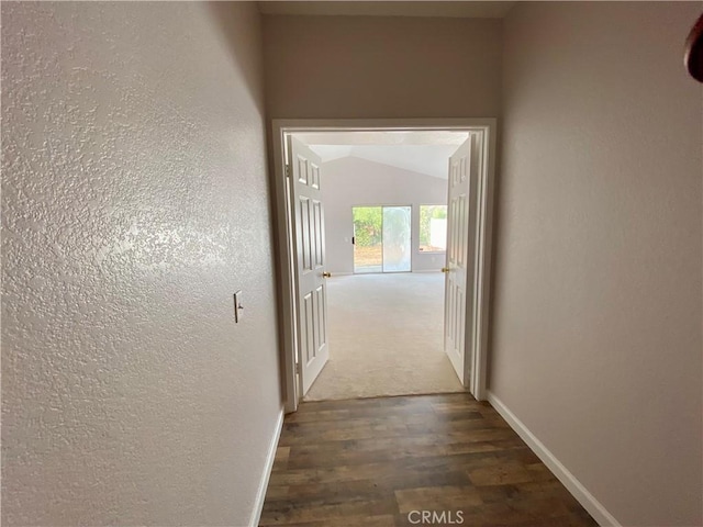 hallway featuring vaulted ceiling and dark hardwood / wood-style floors