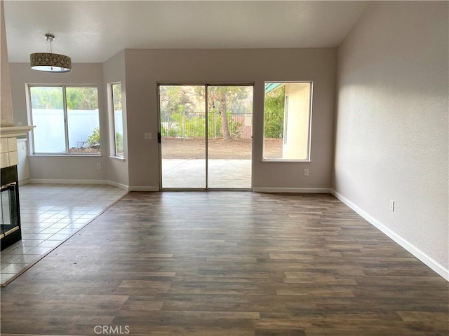 interior space with dark wood-type flooring and a tiled fireplace