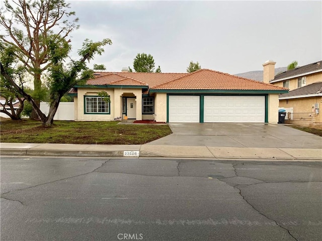 mediterranean / spanish-style home with a front yard and a garage